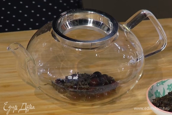 Чай и смородину поместить в заварочный чайник и залить кипятком на половину объема.