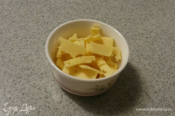 Сыр (у меня была нарезка «Маасдама», но можно любой сыр, и лучше нарезкой, т. к. проще резать) нарезать небольшими прямоугольниками. В ингредиентах указан вес 2 кусочков сырной нарезки.