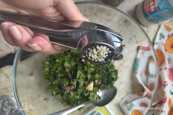 Измельчить зубчик чеснока с помощью чеснокодавилки и добавить к салату.