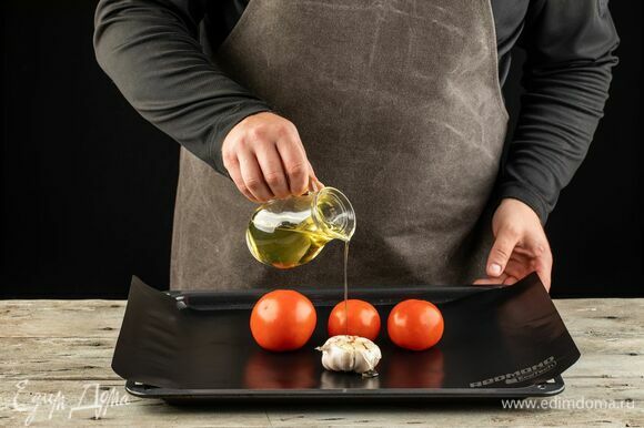 У чеснока срежьте верхушку, у помидоров проткните кожуру. Выложите на противень, застеленный мультипокрытием REDMOND, сбрызните оливковым маслом. Запекайте при 180°С помидоры — 15 минут, чеснок — 30 минут.