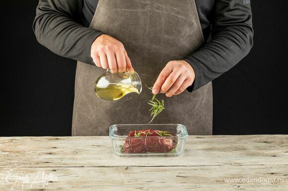 Положите туда же веточки розмарина, влейте оливковое масло. Поставьте мясо мариноваться в холодильник на 1 час.