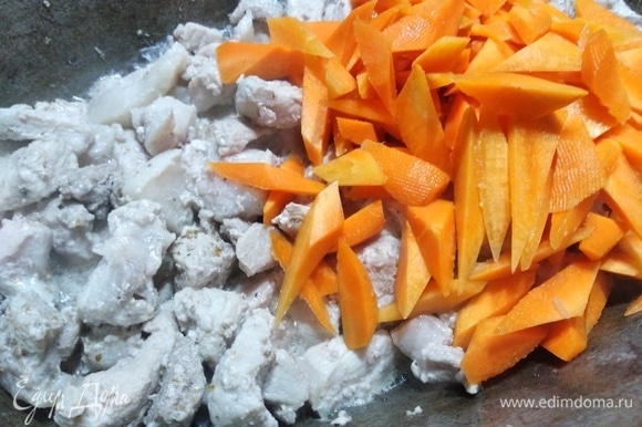 Свинину нарезать, посыпать перцем, припустить на растительном масле до испарения жидкости. Добавить нарезанную морковь. Жарить 5 минут.