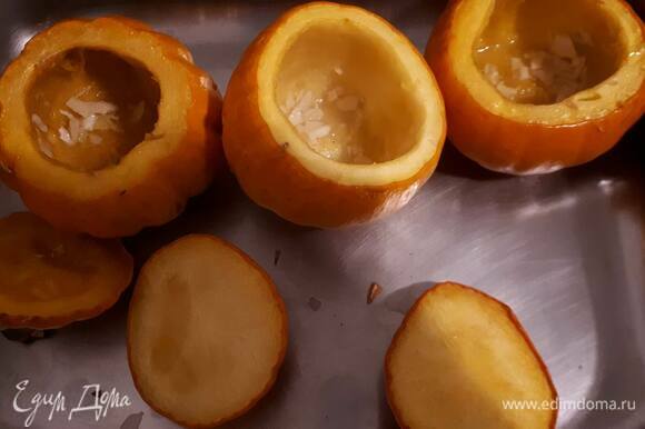 Срежьте верхушки у тыкв, вычистите семечки и мякоть, натрите тыквы внутри маслом с чесноком и поставьте в духовку при 180°C примерно на 35 минут.
