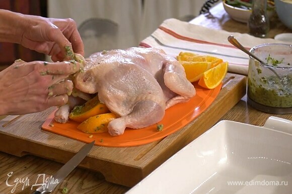 Тушку курицы вымыть, просушить, смазать внутри пряной заправкой и выложить туда несколько долек апельсина.