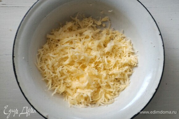 Сыр натереть на средней терке. Чеснок очистить, измельчить в пюре. Половину сыра отложить.