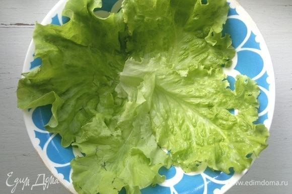 Листья салата вымыть, обсушить. Застелить листьями дно тарелки для подачи.