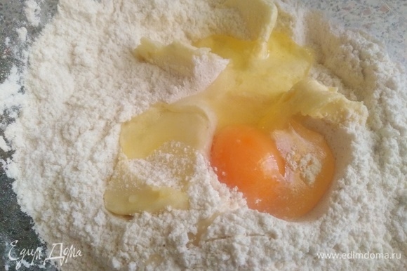 Муку смешать с солью, сахаром и разрыхлителем. Добавить холодное сливочное масло и яйцо.