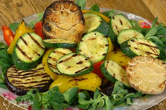 Все оставшиеся овощи обжарить на сковороде-гриль и выложить на салат вместе с запеченным чесноком.