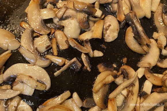 Отдельно обжариваем грибы на оставшемся масле с целыми зубчиками чеснока. Желательно обжаривать в несколько этапов, покрывая грибами только дно сковороды, чтобы грибы не давали воду.