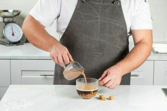 В чашку со свежесваренным кофе влейте молочно-шоколадную смесь, по желанию добавьте сахар.