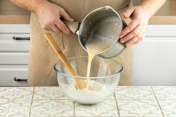 Влейте в муку молоко с маслом, замешайте однородное тесто, уберите его в пакет и оставьте на 30 минут.