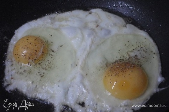 Грудинку обжарить на сковороде и отложить на тарелку. В эту же сковороду разбить два яйца, поперчить и жарить на небольшом огне, пока не затвердеет белок.