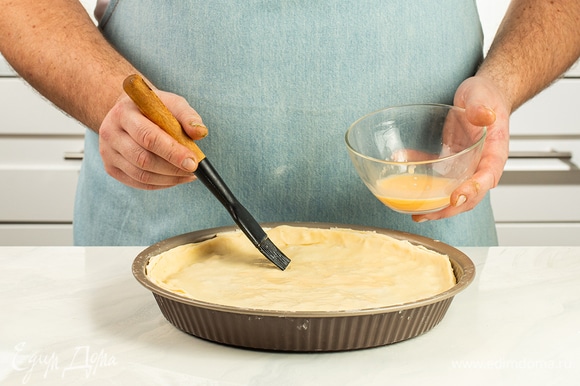 Взбейте яйца для смазывания теста и нанесите половину смеси на пирог.