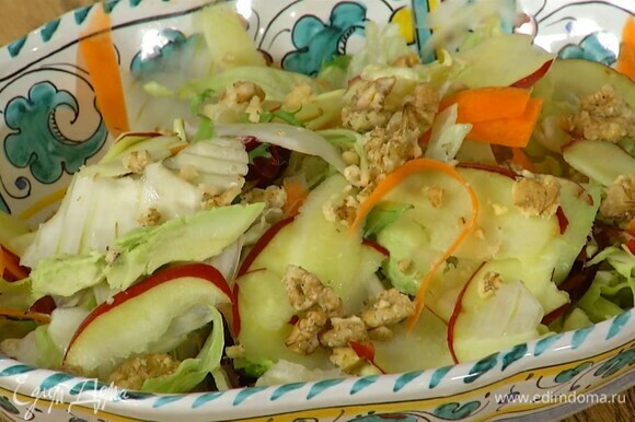 Салатные листья выложить в глубокую салатницу, добавить нарезанные огурец, морковь, фенхель, авокадо и яблоко, посыпать все поломанными руками орехами.