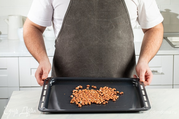 Сырой арахис выложите на противень и отправьте в духовку, разогретую до 180°С, на 10 минут.