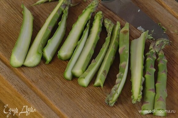Спаржу, удалив грубые черенки, разрезать вдоль пополам.