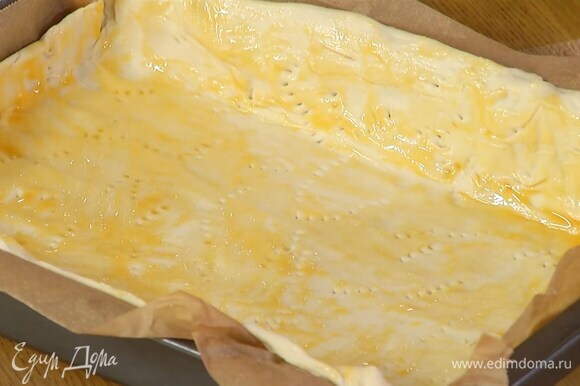 Сформировать из теста бортики, часто наколоть его вилкой и смазать яичным желтком с солью.