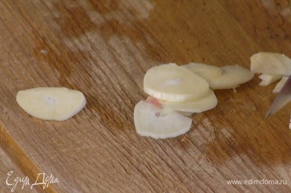 Чеснок почистить и нарезать пластинками.