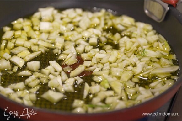 Разогреть в сковороде 80–90 мл оливкового масла, выложить фенхель, перемешать и томить на медленном огне.